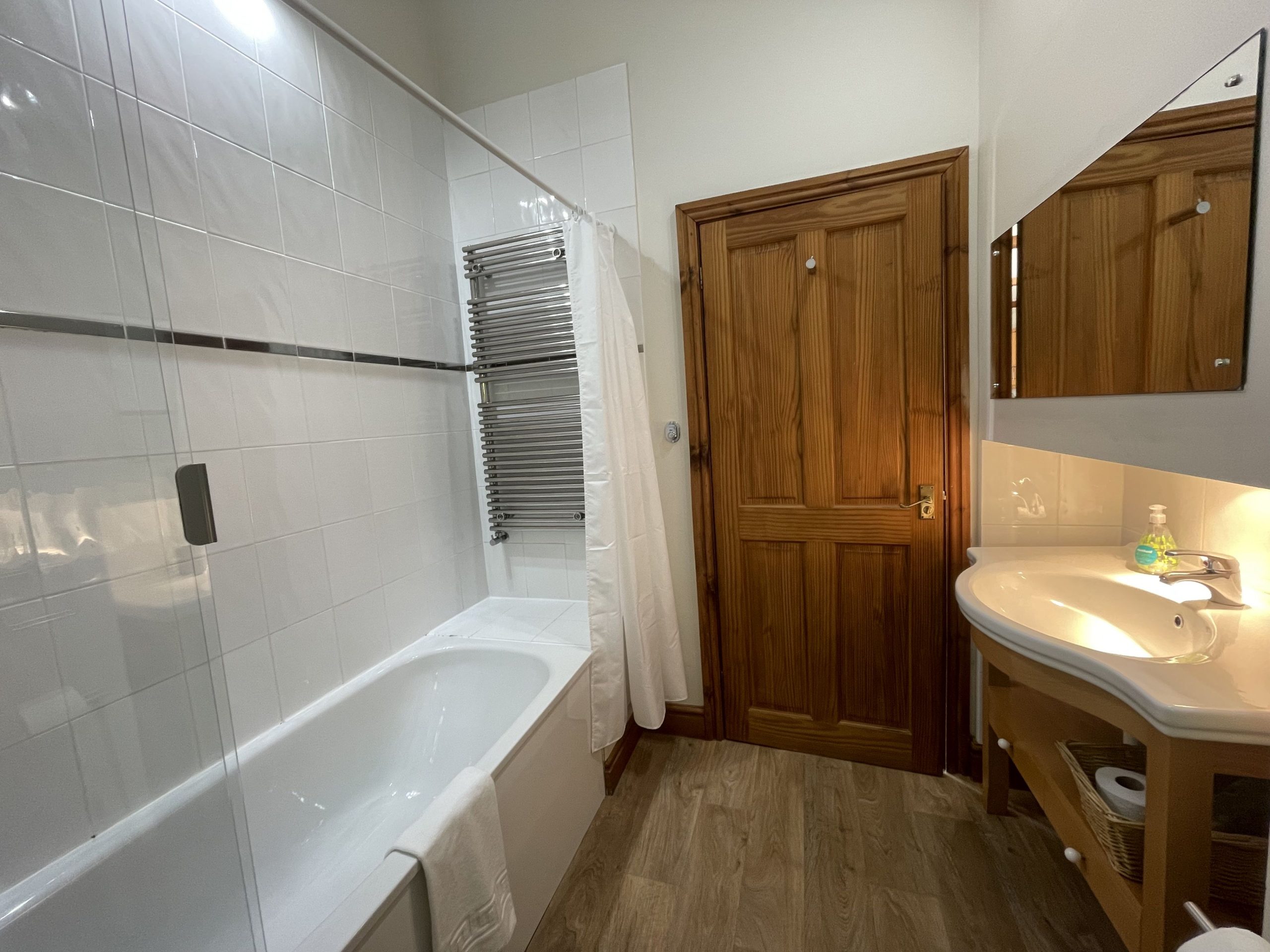 The bathroom comprises bath with shower, sink, WC and heated towel rail