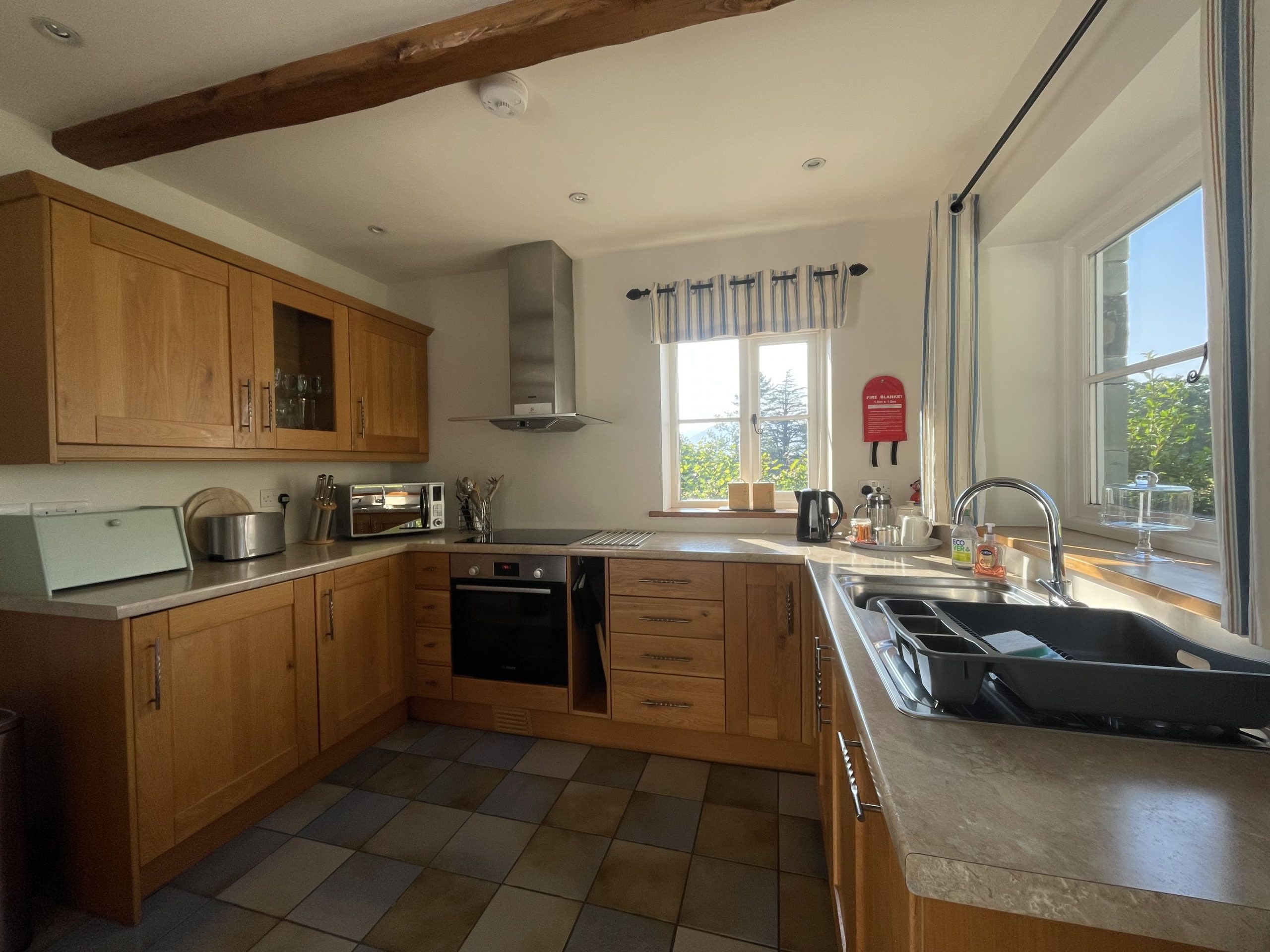 The kitchen is well equipped with electric oven and hob, fridge with freezer shelf, dishwasher, microwave, and plenty of cookware