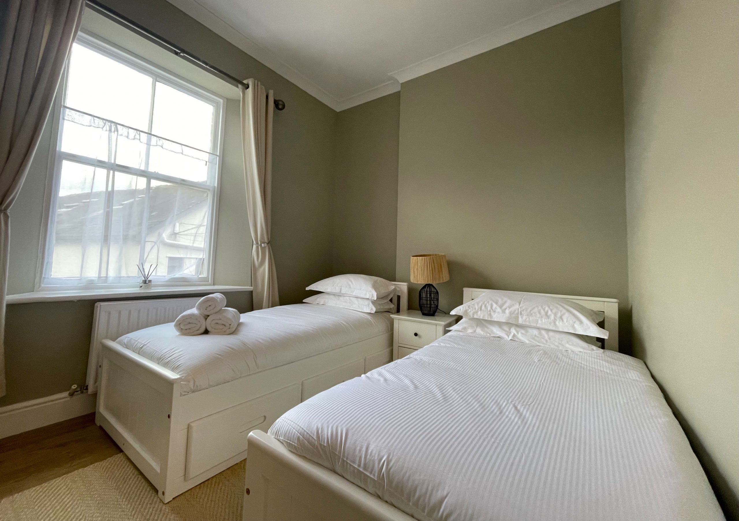 The twin bedroom is furnished with 2 single beds, wardrobe and chest of drawers