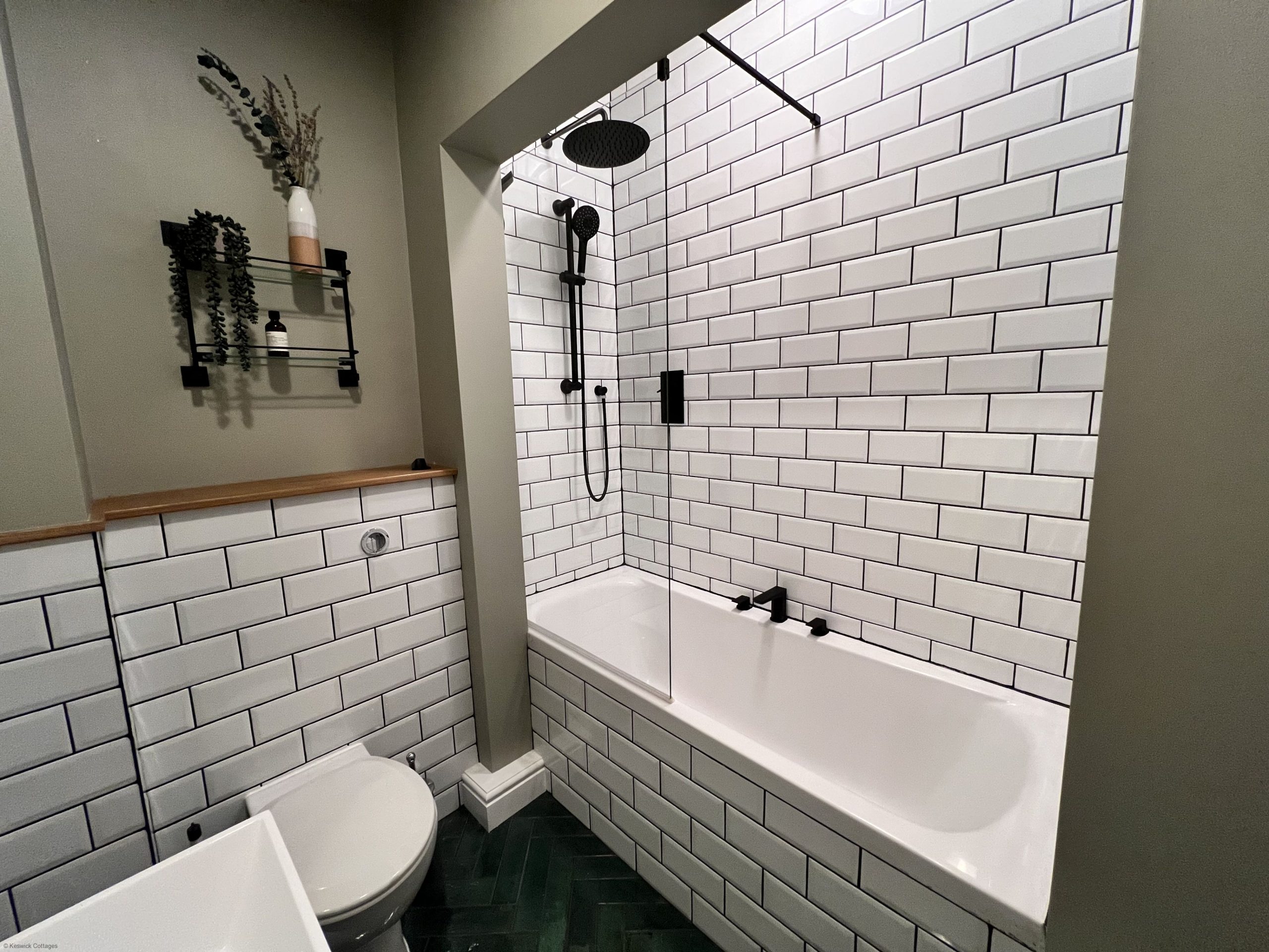 The bathroom comprises bath with overhead waterfall shower, WC, sink and heated towel rail