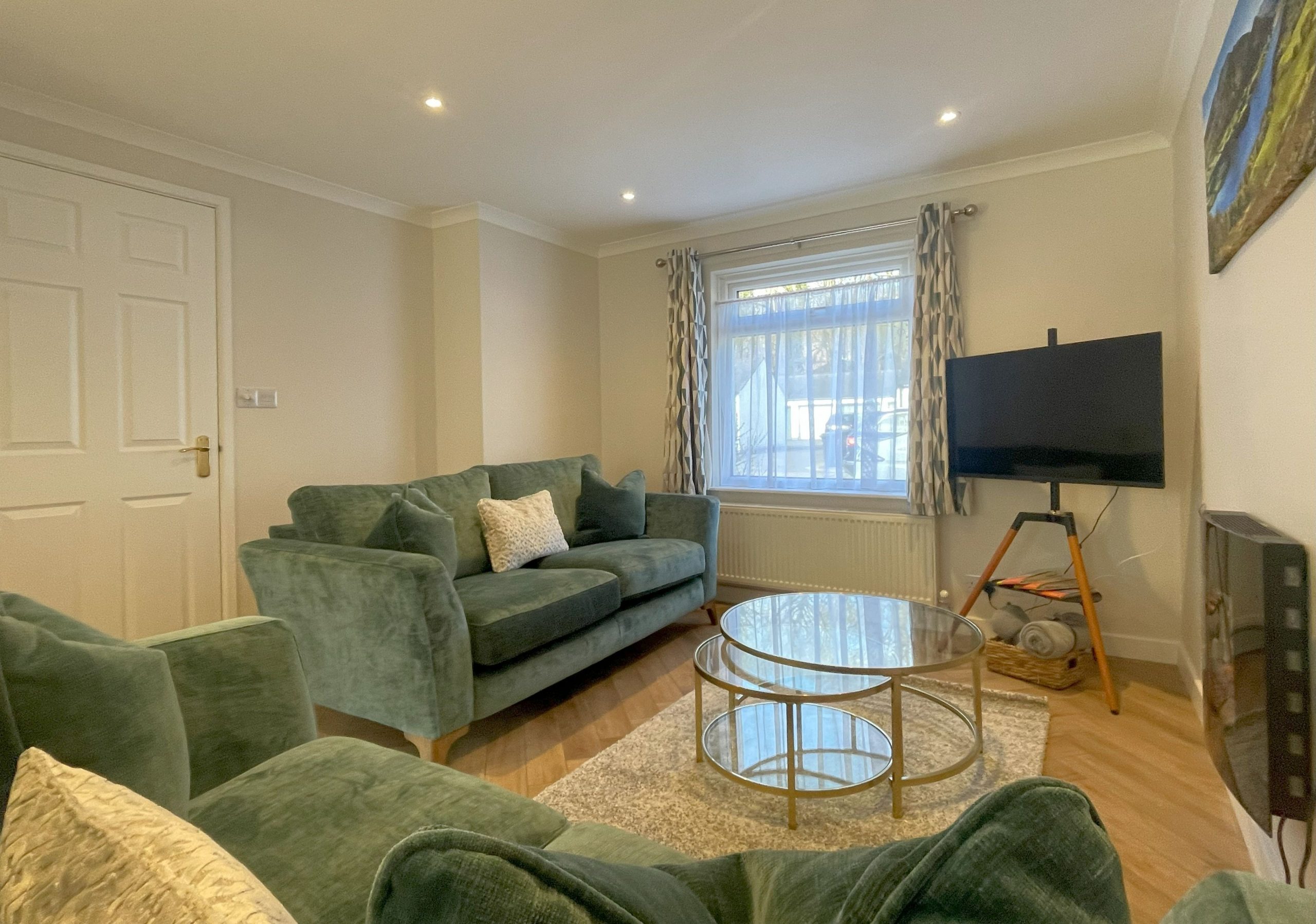 The living space to the front of the property has two comfortable and stylish sofas, a Samsung Frame smart TV, and an electric fireplace. 