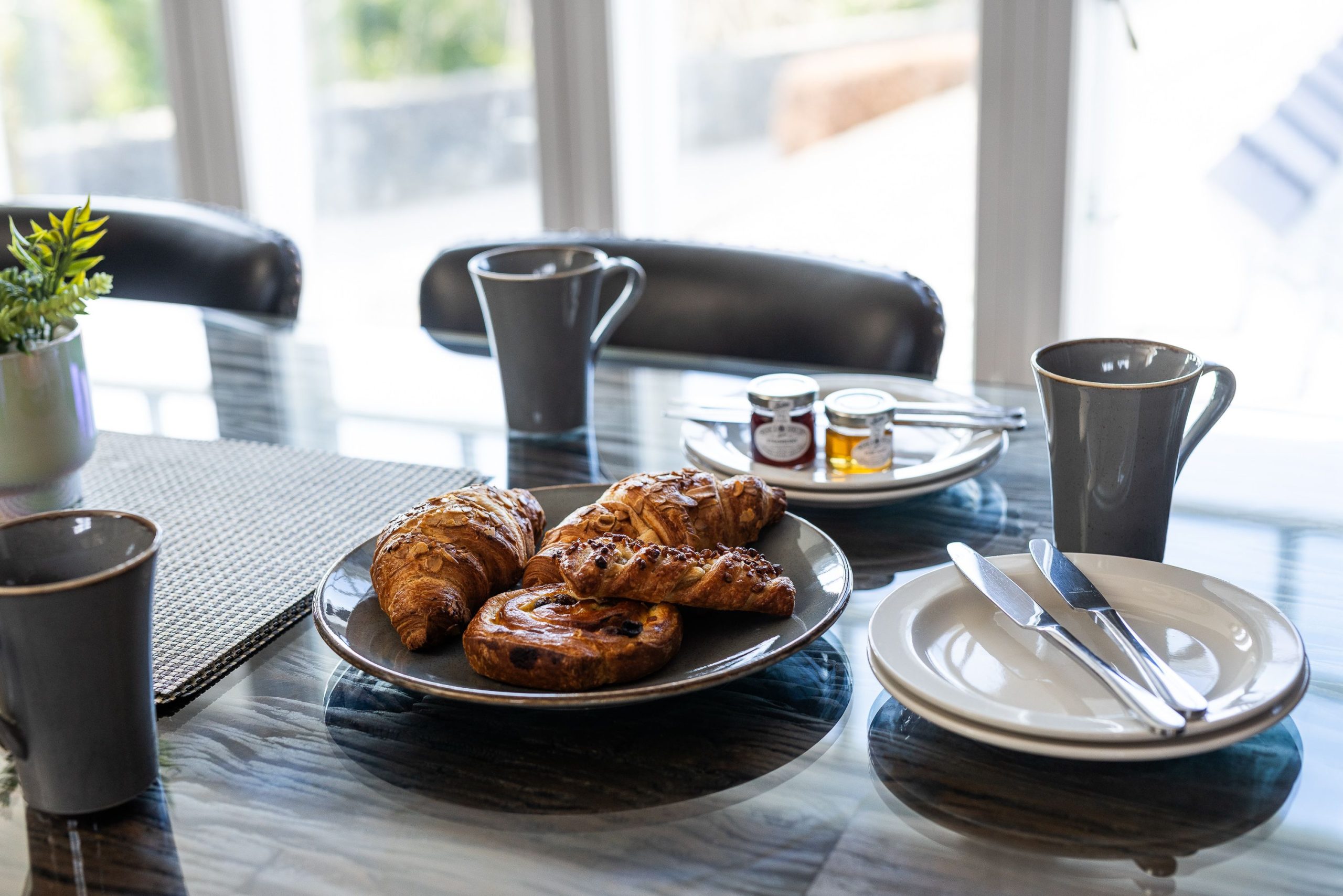 To the side the large family dining table is set into the bay window, with views over the lower roof to the northern fells.