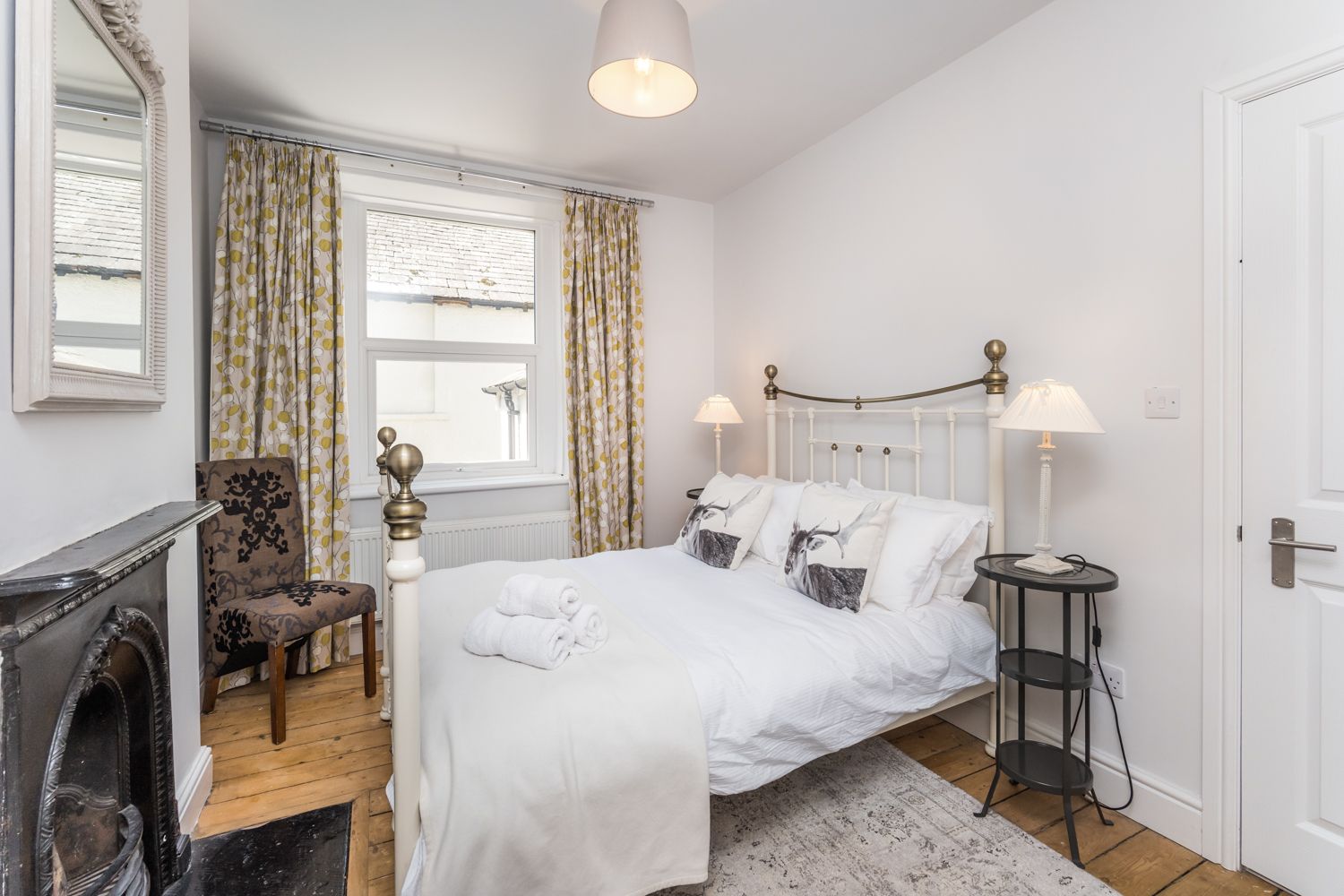 This bedroom is furnished with a double bed, wardrobe, chest of drawers and bedside tables