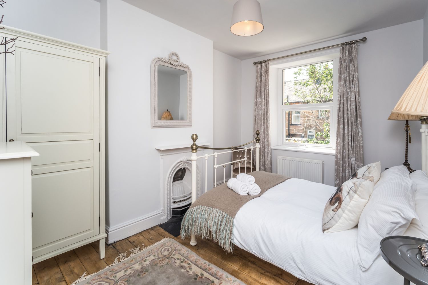 This room is furnished with a double bed, wardrobe, chest of drawers and bedside tables