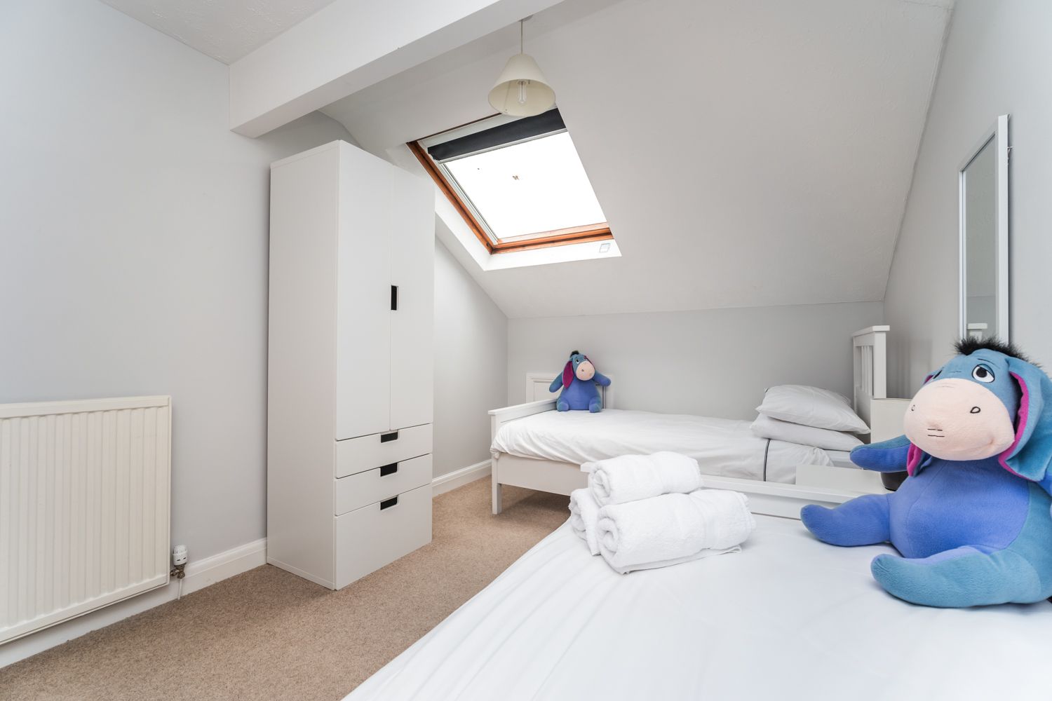 The room is furnished with 2 single beds and a wardrobe