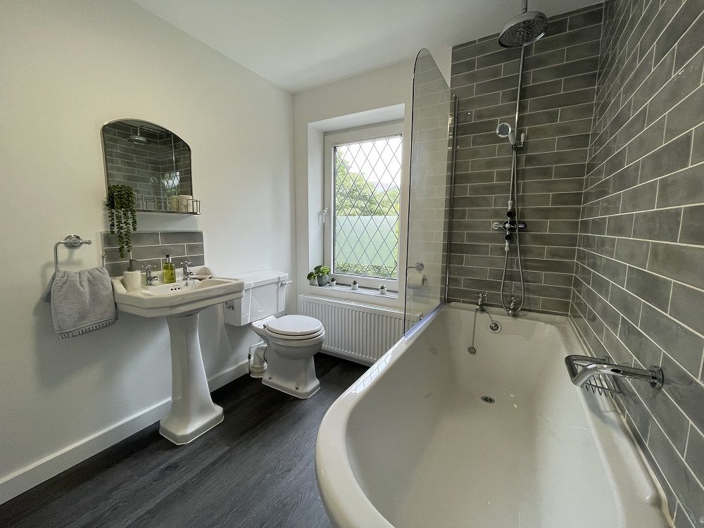 The bathroom comprises bath with overhead waterfall and handheld shower, WC and hand sink