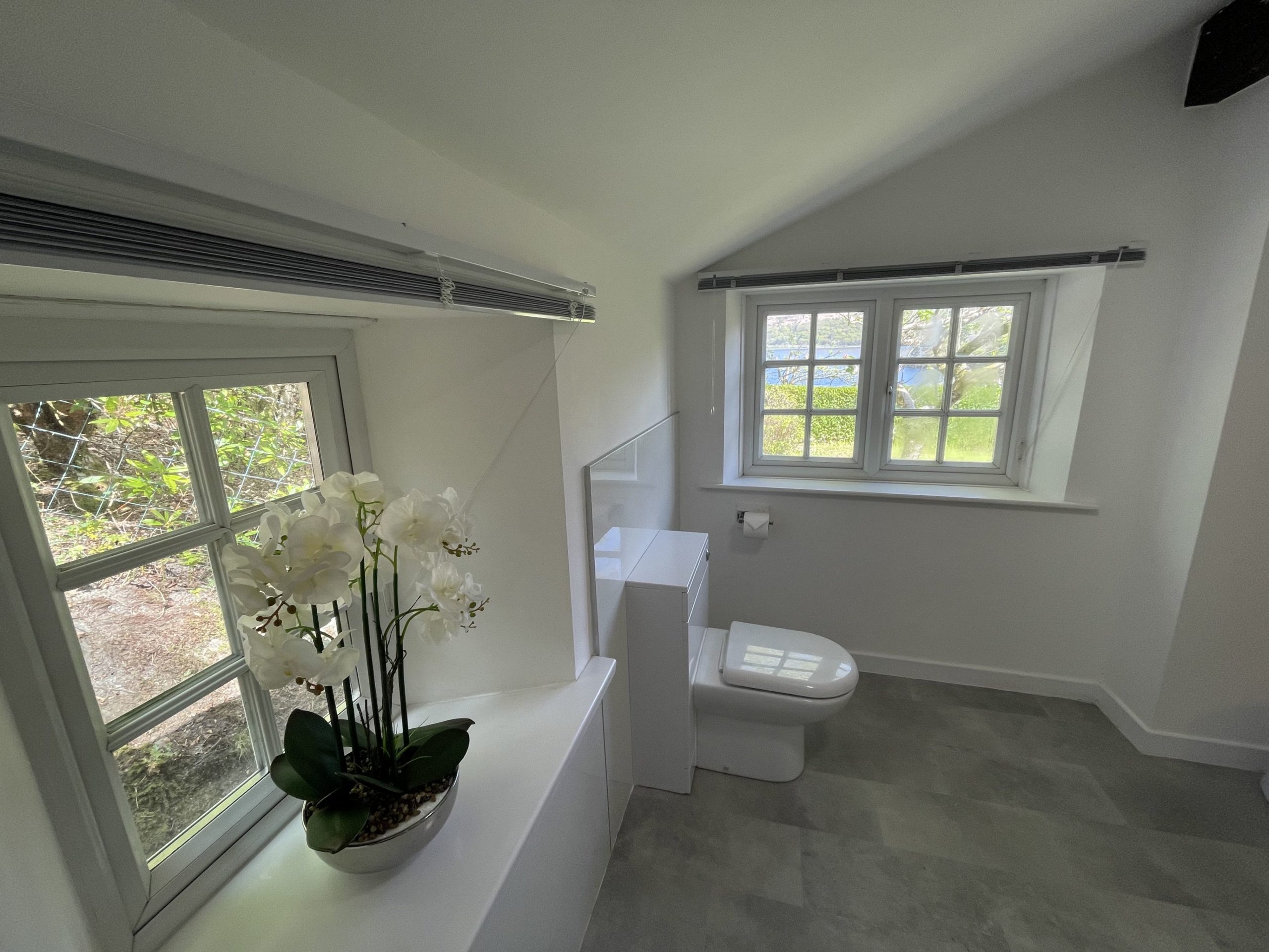 The modern shower room comprises of a walk in shower, WC and hand sink