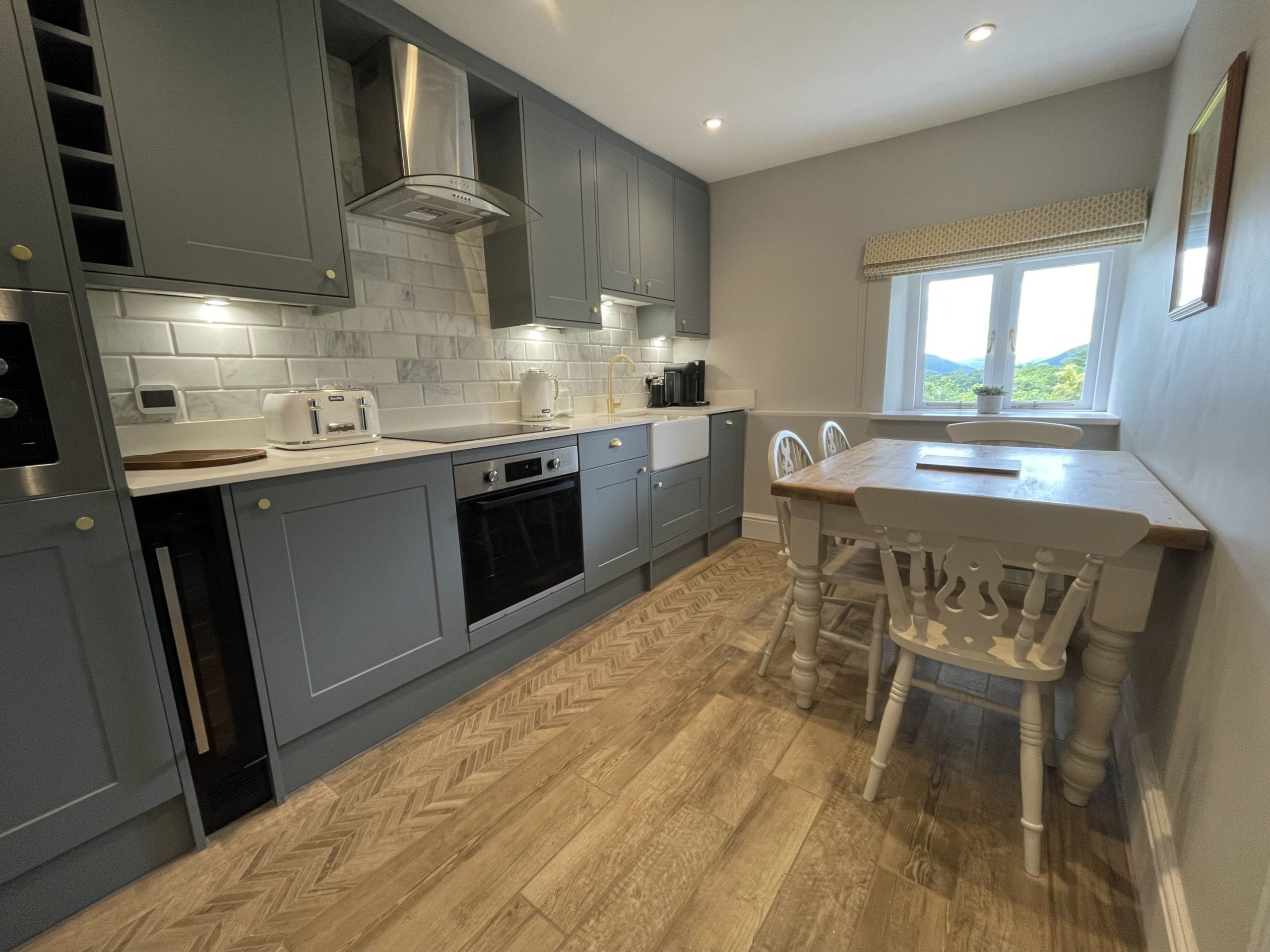 he kitchen is well stocked with plenty of cookware, crockery and glassware, and is fitted with an under counter fridge, dishwasher, integrated microwave, electric hob, oven, plenty of cupboard space, and a stunning butlers sink