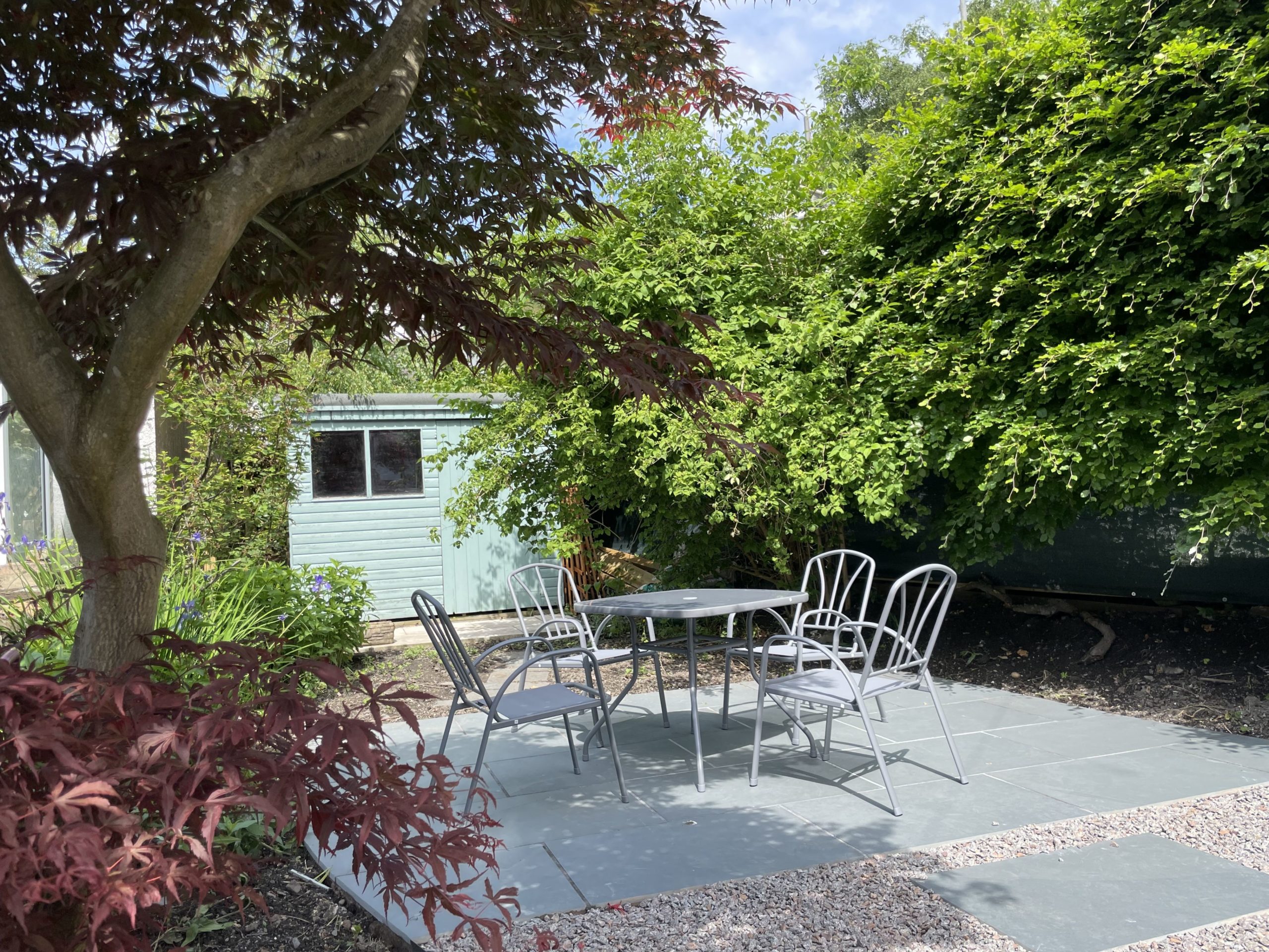 The garden has an outdoor dining space for the warmer days