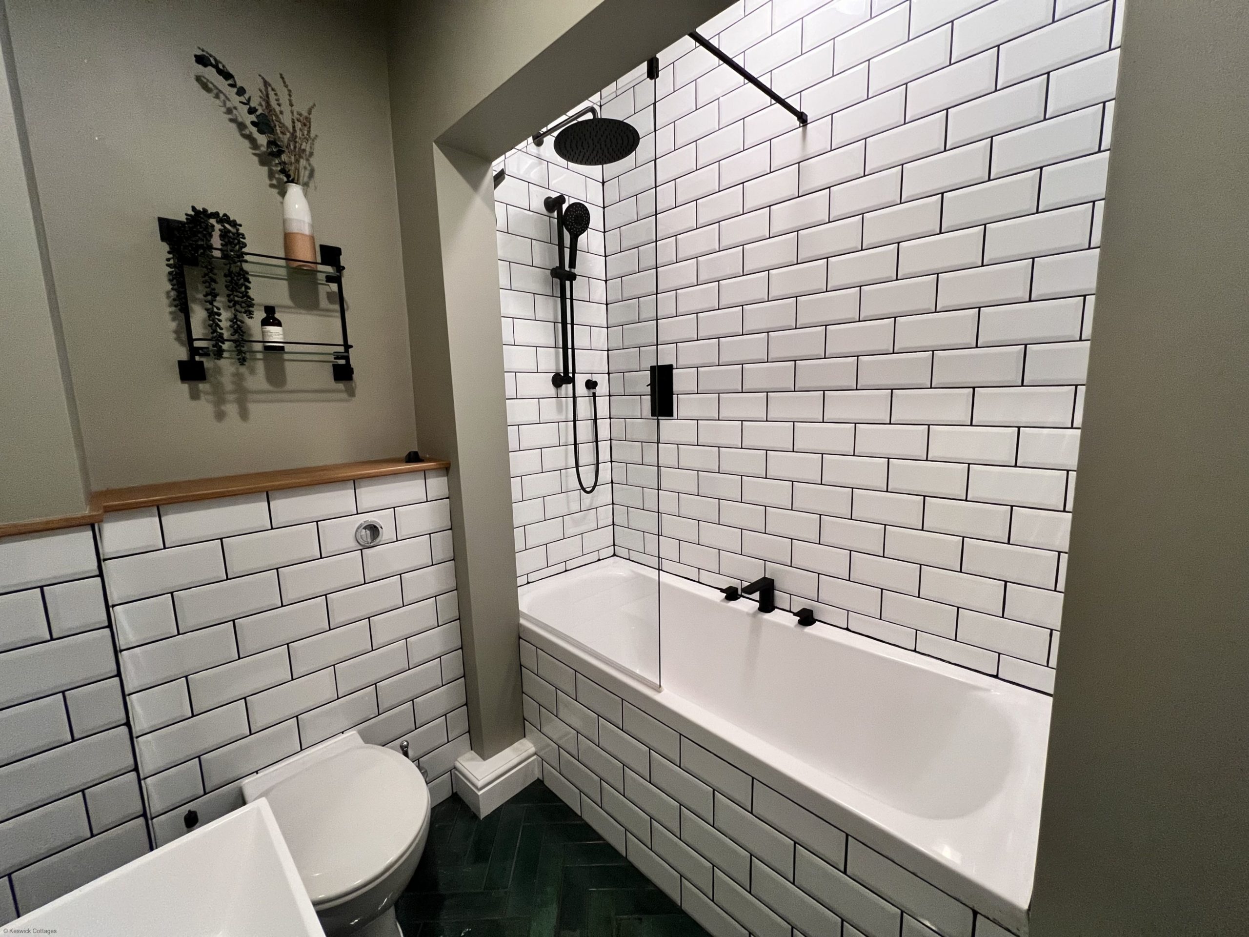The bathroom comprises bath with overhead waterfall shower, WC, sink and heated towel rail